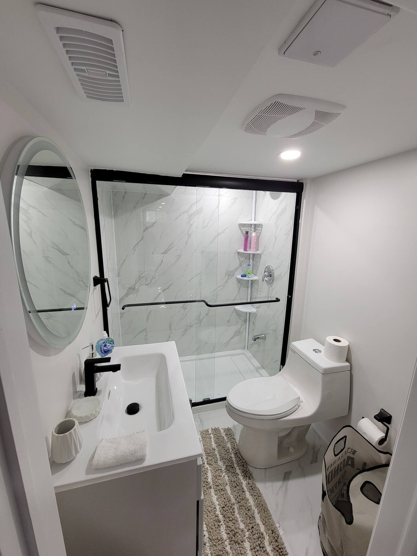 Renovated washroom with tiled shower and glass screen